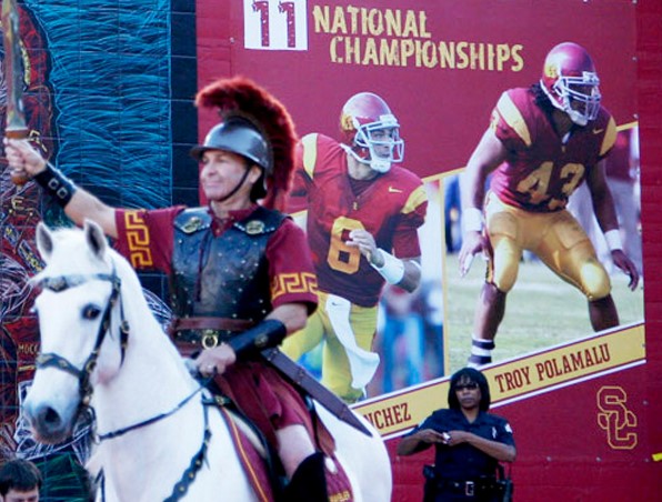 Traveler enters the Los Angeles Memorial Coliseum in front of the mural before the game