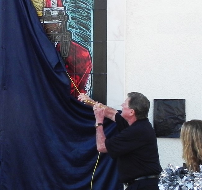 John Hamilton unveils the Lott IMPACT Trophy Mural before the media and crowd