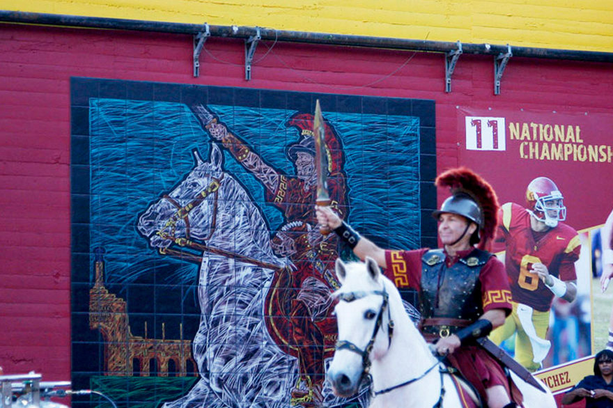 Traveler riding by the USC Traveler Mural at the Los Angeles Memorial Coliseum