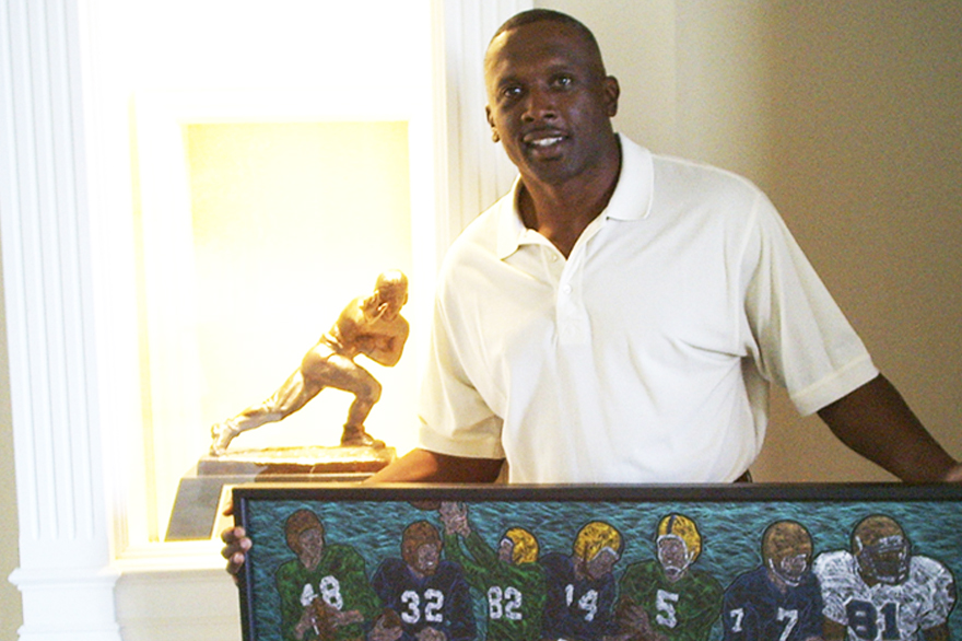 Hall of Famer WR Tim Brown at home with canvas giclee of ND Heisman Winners